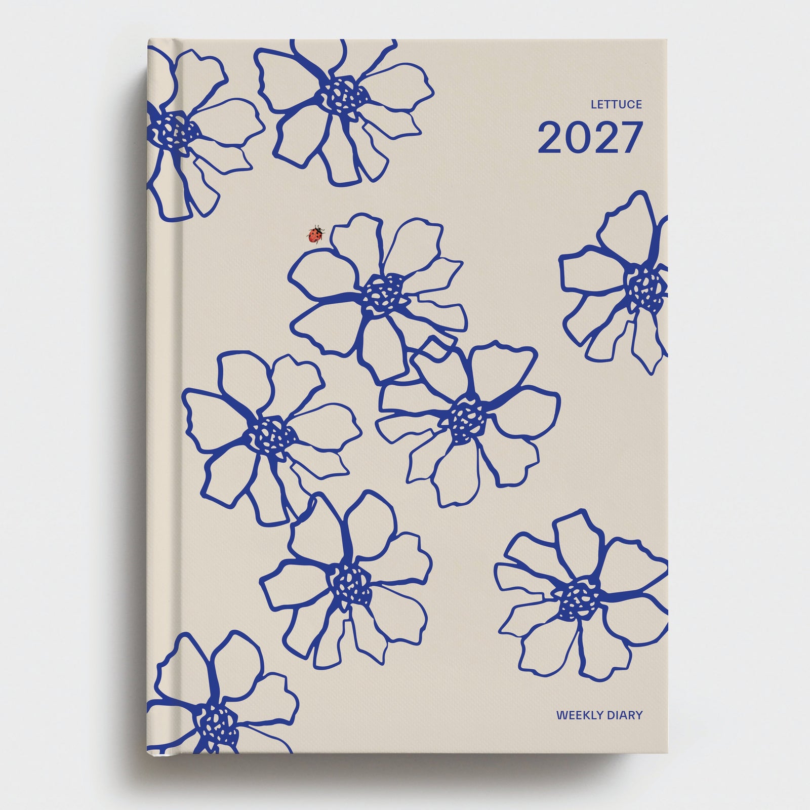 Beige diary with blue floral patterns and '2027' on a white background