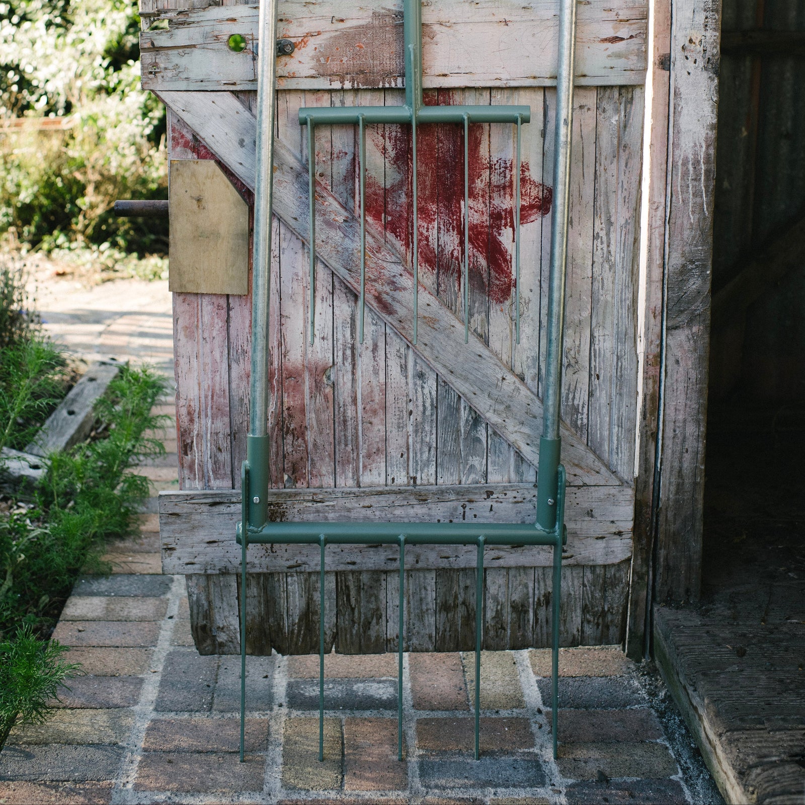 Rustic wooden door with a metal chair against it, outdoors.