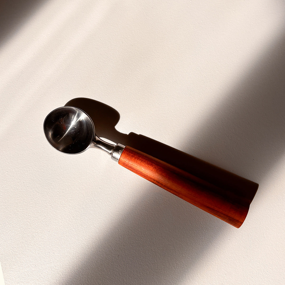 Ice cream scoop with wooden handle on a light background