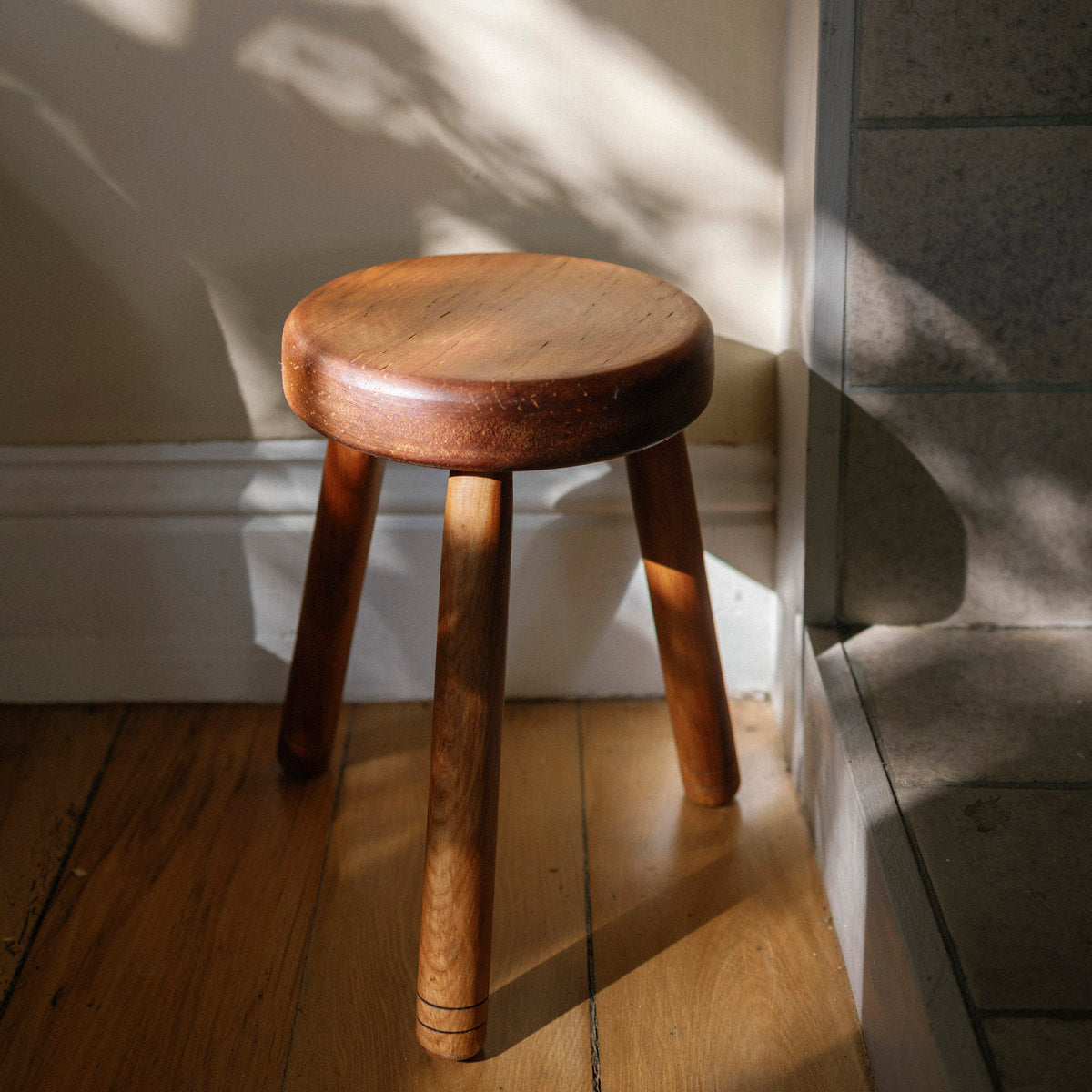 Wooden stool on a wooden floor with soft shadows
