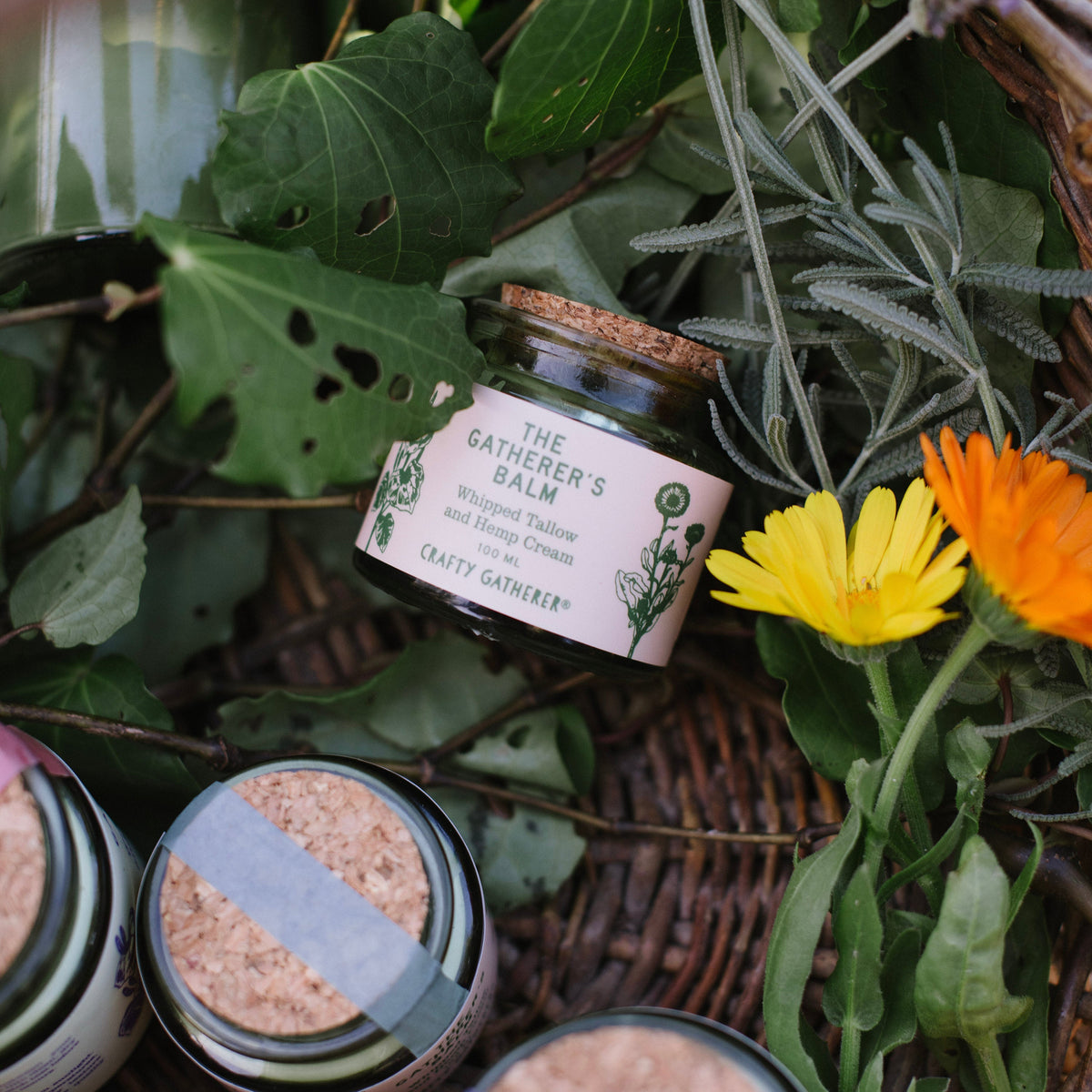 Small glass jar with a label on a bed of green leaves and flowers