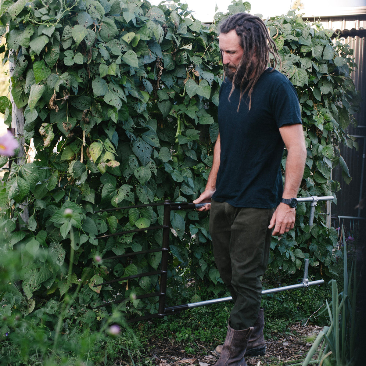 Man standing in a garden with greenery and plants around him