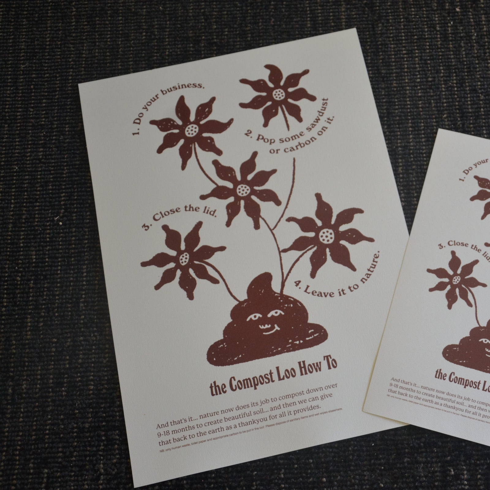 Two printed sheets with composting toilet instructions and illustrations on a textured surface.