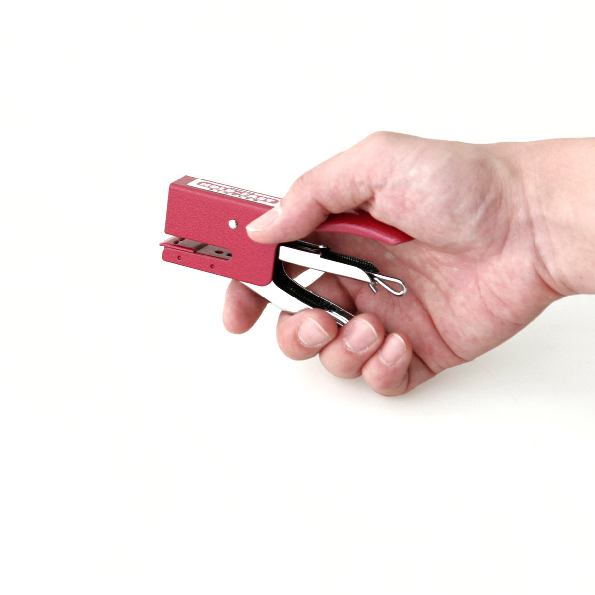 Hand holding a red stapler against a white background