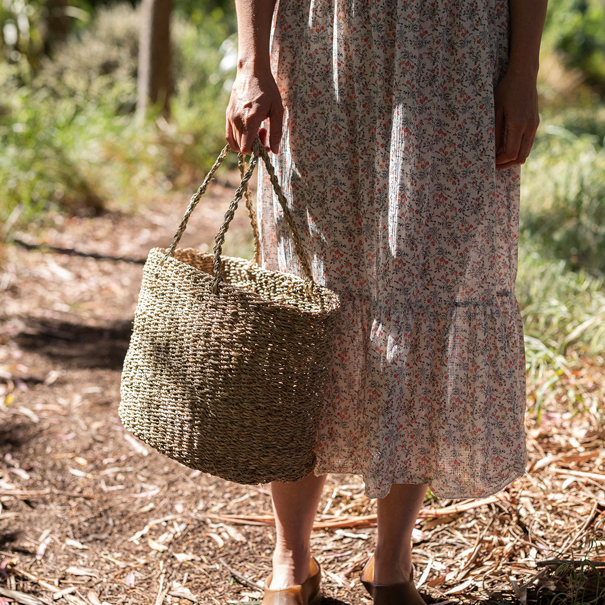 Person holding a woven basket in a natural setting