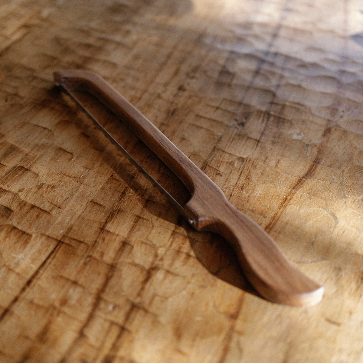 Wooden breadknife on a wooden surface