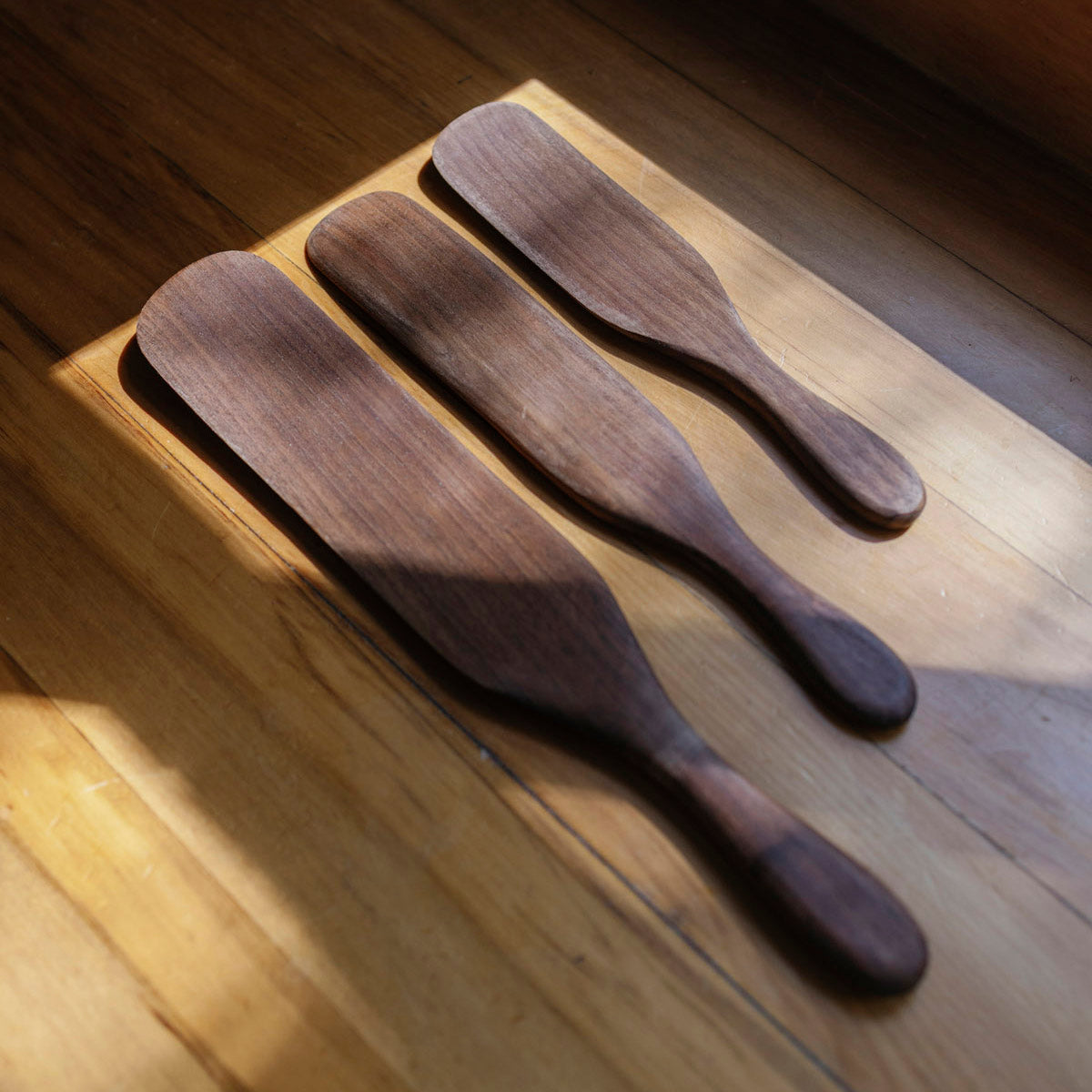 Three wooden spoons on a wooden surface